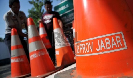   Petugas dinas perhubungan provinsi Jawa Barat mempersiapkan sejumlah rambu-rambu dan pembatas jalan di Jembatan Timbang Tomo, Sumedang, Jawa Barat, Senin (29/7).   (Republika/Prayogi)