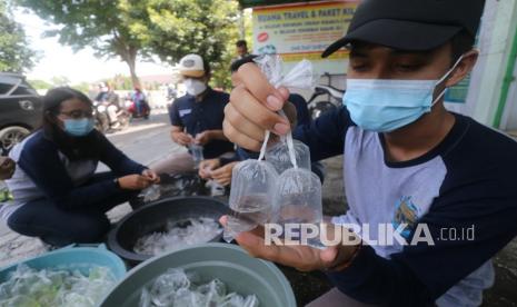 Petugas Dinas Perikanan membagikan ikan hias kepada pengguna jalan di Desa Paron, Kediri, Jawa Timur, Jumat (19/11/2021). Kegiatan membagikan ikan hias sebanyak 3.000 ekor ikan cupang, 1.500 ekor ikan komet, dan 200 ikan gupi tersebut guna memperingati Hari Ikan Nasional sekaligus sebagai upaya pemerintah daerah setempat mengendalikan penyebaran demam berdarah saat musim hujan melalui pembagian ikan predator jentik nyamuk. 