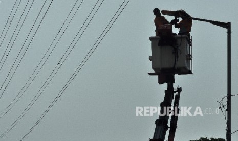 Petugas Dinas Perindustrian dan Energi mengganti lampu penerangan jalan umum (PJU) di kawasan Jalan Kali Sekretaris, Jakarta Barat, Senin (21/8).