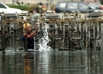 Petugas Dinas Pertamanan dan Pemakaman DKI membersihkan tiang lampu yang berada pada kolan Bundaran Hotel Indonesia (HI), jakarta Pusat, Jumat (25/11). (Republika/Agung Supriyanto)