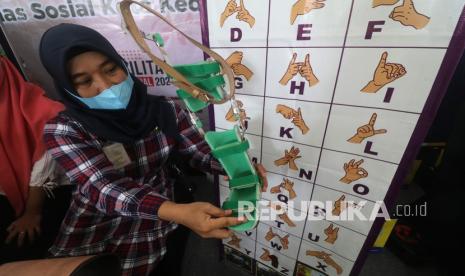 Petugas dinas sosial memperlihatkan alas kaki untuk warga berkebutuhan khusus pada pameran produk karya penyandang disabilitas memperingati Hari Disabilitas Internasional di Balai Kota Kediri, Jawa Timur, Jumat (3/12/2021). Pemerintah daerah setempat bersama United States Agency International Development (USAID) memberikan program Jadi Pengusaha Mandiri (JAPRI) melalui pelatihan kewirausahaan bagi penyandang disabilitas.