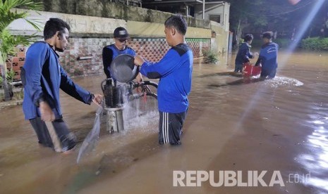 Petugas Dinas Tata Air menjaga agar pipa penghisap air tidak tersumbat sampah yang terhanyut banjir di Kawasan Kemang, Jakarta, Ahad (28/8). (Foto: Yogi Ardhi/Republika)