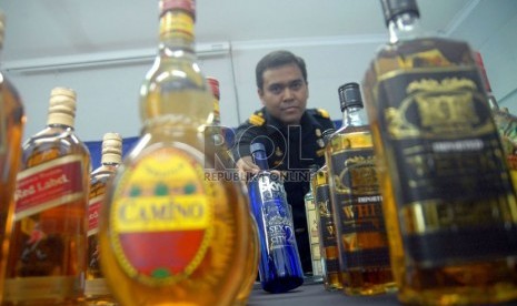   Petugas Direktorat Jendral Bea Cukai menunjukkan botol minuman keras hasil sitaan operasi terpadu di kantor Direktorat Jenderal Bea dan Cukai kanwil Jakarta, Kemayoran, Jakarta Pusat, Rabu (10/10).  (Agung Fatma Putra)