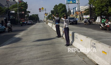 Petugas Dishub DKI Jakarta mengatur lalu lintas saat uji coba penutupan tiga simpang di kawasan Jalan Mampang Prapatan Raya, Jakarta, Sabtu (19/5).