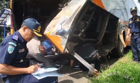 Petugas Dishub Kabupaten Bogor melakukan pengecekan kondisi bus HS Transpot yang menyebabkan kecelakaan maut di jalur Puncak saat penyelidikan di Pos Terpadu Unit Laka Lantas Polres Bogor, Tol Jagorawi, Ciawi, Kabupaten Bogor, Jawa Barat, Minggu (23/4). 