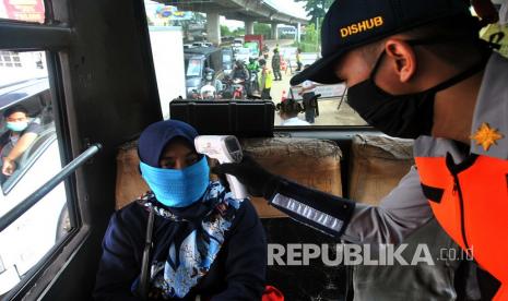 Petugas dinas perhubungan memeriksa penumpang bus dalam menegakkan psysical distancing (ilustrasi).