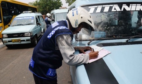 Petugas Dishub memeriksa surat kelengkapan angkutan umum di Terminal Pasar Minggu, Jakarta Selatan. (Republika/Yasin Habibi)