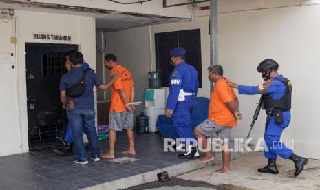 Petugas Ditpolairud Polair Polda Kepri menggiring dua tersangka kasus penyelundupan Pekerja Migran Indonesia (PMI) menuju ke ruang tahanan sementara, di Mako Ditpolairud Polda Kepri Sekupang, Batam, Kepulauan Riau, Kamis (20/1/2022). BP2MI menyatakan telah menyerahkan 40 kasus pekerja migran ilegal ke Mabes Polri.