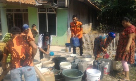 Petugas DPKPB dan PDAM Kabupaten Purwakarta, mendistribusikan bantuan air bersih bagi warga yang terdampak kekeringan, Kamis (25/7). 