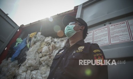 Petugas gabungan Bea dan Cukai, Kementerian Lingkungan Hidup, Kementerian Perdagangan dan Polri mengecek sampah plastik yang mengandung limbah berbahaya dan beracun (B3) sebelum diangkat ke atas kapal untuk di re-ekspor ke negara asal di Pelabuhan Batu Ampar, Batam, Kepulauan Riau, Senin (29/7/2019).