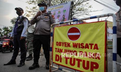 Petugas gabungan berjaga di pintu masuk area Pantai Tanjung Pasir, Kabupaten Tangerang, Banten, Ahad (16/5/2021). Pemerintah Provinsi Banten menutup objek wisata di Banten sejak 15 Mei hingga 30 Mei 2021 guna mencegah penularan COVID-19 pada klaster libur Idul Fitri 1442 H. 