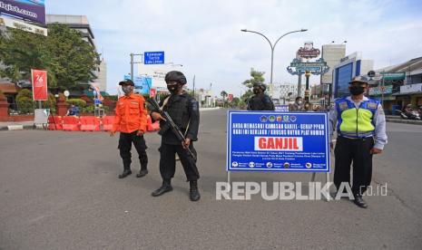 Petugas gabungan berjaga saat uji coba ganjil genap di jalan RA Kartini, Kota Cirebon, Jawa Barat, Jumat (13/8/2021). Pemkot Cirebon menerapkan sistem ganjil genap di delapan ruas jalan di kota pada pukul 13.00-17.00 WIB untuk mengendalikan mobilitas warga sebagai upaya menurunkan angka penyebaran COVID-19. 