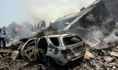  Petugas gabungan berusaha memadamkan api pada pesawat Hercules yang jatuh di Jalan Jamin Ginting, Medan, Sumatera Utara, Selasa (30/6).