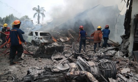 Petugas gabungan berusaha memadamkan api pesawat Hercules yang jatuh, di Jalan Jamin Ginting, Medan, Sumatera Utara, Selasa (30/6).