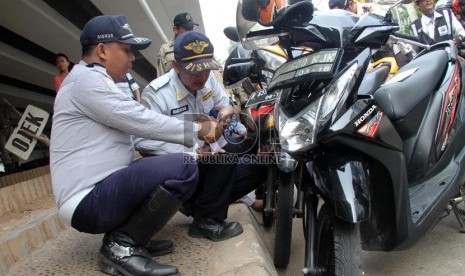  Petugas gabungan dari Suku Dinas Perhubungan dan Satlantas Jakarta Pusat melakukan penertiban parkir kendaraan liar di badan jalan dan trotoar di bawah jalan layang Roxy, Jakarta, Selasa (17/9).     (Republika/Yasin Habibi)