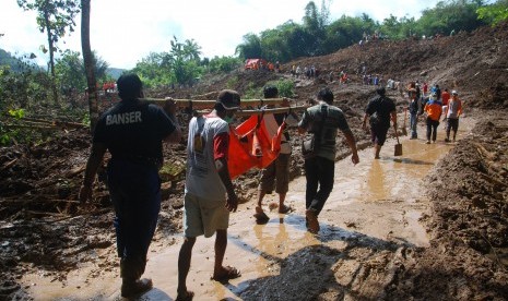 Petugas gabungan dari TNI, BASARNAS, Polri, relawan dan warga membawa kantong jenazah berisi korban tanah longsor di Caok, Loano, Purworejo, Jawa Tengah, Selasa (21/6).