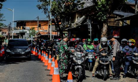 Petugas gabungan dari TNI, Polri, Satpol PP, dan Dinas Perhubungan melakukan pengecekan Surat Tanda Registrasi Pekerja (STRP) atau surat tugas di posko penyeketan Lenteng Agung, Jakarta.