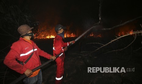 Petugas gabungan Manggala Agni Daops Banyuasin, BPBD Prov Sumsel, BPBD OI, TNI dan Polri melakukan pemadaman kebakaran lahan di Desa Pelabuhan Dalam, Pemulutan, Ogan Ilir (OI), Sumatera Selatan, Jumat (8/4). 