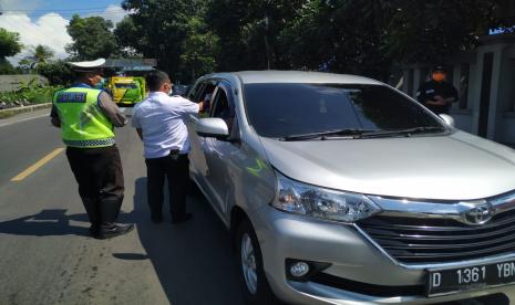 Petugas gabungan melakukan pemeriksaan kepada warga yang masuk Kota Tasikmalaya di wilayah perbatasan, Kecamatan Indihiang, Kota Tasikmalaya, Selasa (31/3).