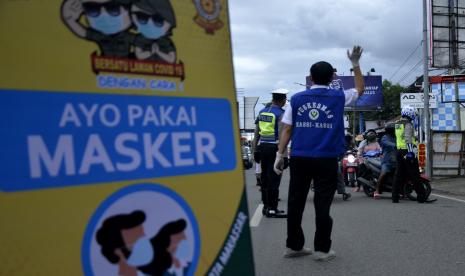 Petugas gabungan melakukan pemeriksaan wajib penggunaan masker kepada pengendara di perbatasan Kabupaten Gowa dengan Makassar, Sulawesi Selatan, Ahad (12/4). Pemerintah Kota Makassar, Sulawesi Selatan, akhirnya resmi menetapkan penerapan secara efektif Pembatasan Sosial Berskala Besar (PSBB) guna memberantas penyebaran Covid-19. Penerapan PSBB dilakukan mulai 24 April 2020 yang bertepatan dengan 1 Ramadhan 1441 Hijiriah.