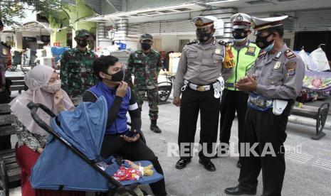 Petugas gabungan melakukan sosialisasi protokol kesehatan di kawasan Malioboro, Yogyakarta, Kamis (24/12/2020). Sosialisasi penerapan protokol kesehatan di kawasan wisata tersebut guna menekan penyebaran COVID-19 selama liburan akhir tahun di Yogyakarta.