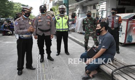 Petugas gabungan melakukan sosialisasi protokol kesehatan di kawasan Malioboro, Kota Yogyakarta, Kamis (24/12).