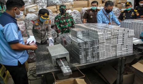 Petugas gabungan memasukan bungkusan rokok ilegal ke dalam mesin pemotong saat pemusnahan barang hasil penindakan di gudang Kantor Wilayah Direktorat Jenderal Bea Cukai (DJBC) Riau, di Pekanbaru, Riau, Rabu (18/11/2020). DJBC Riau memusnahkan sebanyak 18,3 juta batang rokok ilegal dengan total nilai barang mencapai Rp 13,39 milyar dengan potensi kerugian negara sebesar Rp 8,1 milyar.