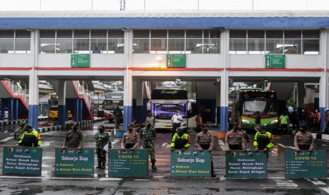 Petugas gabungan membawa poster himbauan penerapan 5M protokol kesehatan di Terminaal Purabaya, Bungurasih, Sidoarjo, Jawa Timur, Kamis (4/2/2021). Sosialisasikan penerapan 5M protokol kesehatan di kawasan terminal dalam pelaksanaan Pembatasan Kegiatan Masyarakat (PPKM) tersebut dilaksanakan Polda Jatim dan Pangdam V Brawijaya bersama Forkopimda Sidoarjo dengan membagikan masker dan sembako kepada penumpang dan kru bus.