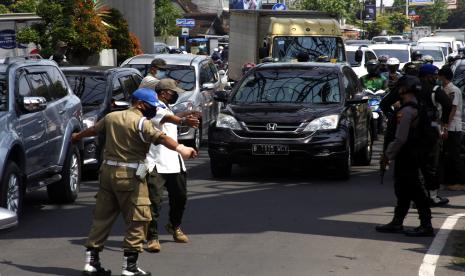 Petugas gabungan memberhentikan dan memeriksa kelengkapan kendaraan asal luar Kota Solo yang melintas di kawasan Tugu Makutho di Solo, Jawa Tengah, Solo, Jawa Tengah, Kamis (6/5/2021). Kegiatan penyekatan larangan mudik di perbatasan Kota Solo tersebut digelar untuk menegakkan aturan pemerintah yang melarang mudik pada momen lebaran 2021 guna memutus mata rantai penyebaran COVID-19. 