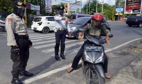 Petugas gabungan memberhentikan penguna jalan yang tidak mengenakan masker saat razia masker di sejumlah jalan protokol di Bandar Lampung, Lampung, Kamis (13/8/2020). Razia yang dilakukan oleh petugas gabungan dari TNI, Polri, Satpol PP dan Dishub Kota Bandar Lampung itu guna mengedukasi masyarakat tentang pentingnya penggunaan masker menyusul bertambahnya kasus positif COVID-19 di Lampung.