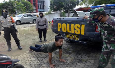 Petugas gabungan memberikan sanksi kepada pengguna jalan yang tidak menggunakan masker saat razia masker di sejumlah jalan protokol di Bandar Lampung, Lampung, Kamis (13/8/2020). Razia yang dilakukan oleh petugas gabungan dari TNI, Polri, Satpol PP dan Dishub Kota Bandar Lampung itu guna mengedukasi masyarakat tentang pentingnya penggunaan masker menyusul bertambahnya kasus positif COVID-19 di Lampung.