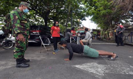 Petugas gabungan memberikan sanksi sosial berupa push up kepada warga yang melanggar saat operasi protokol kesehatan. (Ilustrasi)