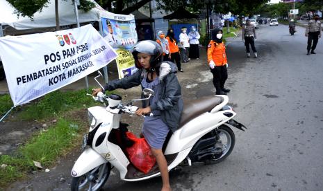 Petugas gabungan meminta seorang pengendara yang tidak menggunakan masker untuk berputar balik saat akan melewati pos pemeriksaan Pembatasan Sosial Berskala Besar (PSBB) di perbatasan Makassar dan Gowa, Sulawesi Selatan, Jumat (24/4/2020). Penerapan PSBB di Makassar yang diberlakukan mulai hari ini tersebut masih ditemukan sejumlah pelanggaran seperti kesadaran warga yang tidak menggunakan masker.