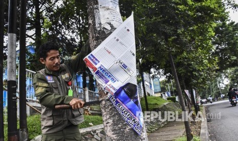 Petugas gabungan mencopot Alat Peraga Kampanye (APK) Pemilu 2019, Ahad (14/4). 