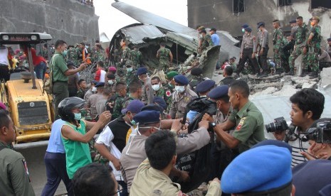 Petugas gabungan mengangkat kantong jenazah korban pesawat Hercules C-130 yang jatuh di Jalan Jamin Ginting, Medan, Sumatera Utara, Selasa (30/6). . (Antara/Irsan Mulyadi)