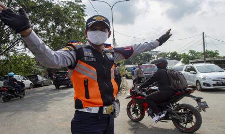 Petugas gabungan mengatur arus lalu lintas kendaraan dari arah Bekasi menuju Karawang saat hari pertama penyekatan larangan mudik di perbatasan Karawang-Bekasi, Jawa Barat, Kamis (6/5/2021). Penyekatan akses transportasi di sejumlah perbatasan kota tersebut dilakukan saat penerapan larangan mudik Lebaran pada 6 -17 Mei 2021 sebagai upaya pencegahan kasus penularan COVID-19.