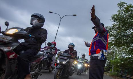 Petugas gabungan mengatur arus lalu lintas kendaraan dari arah Bekasi menuju Karawang saat hari pertama penyekatan larangan mudik di perbatasan Karawang-Bekasi, Jawa Barat. Penyekatan akses transportasi di sejumlah perbatasan kota tersebut dilakukan saat penerapan larangan mudik Lebaran pada 6 -17 Mei 2021 sebagai upaya pencegahan kasus penularan COVID-19.