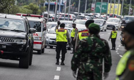 Petugas gabungan mengatur lalu lintas kendaraan dari luar kota saat penerapan Pembatasan Sosial Berskala Besar (PSBB) di Pasteur, Bandung, Jawa Barat, Rabu (22/4/2020). Pemeriksaan tersebut dilakukan untuk mengingatkan masyarakat agar menerapkan PSBB selama 14 hari dalam rangka percepatan penanganan COVID-19.