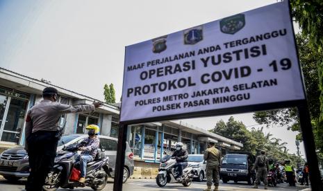 Petugas gabungan mengatur lalu lintas saat Operasi Yustisi Protokol Covid-19 di kawasan Jati Padang, Jakarta.