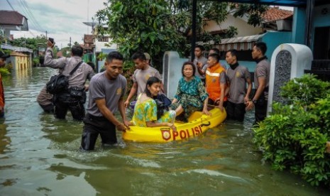 Petugas gabungan mengevakuasi warga terdampak banjir di Kecamatan Pekalongan Utara, Jawa Tengah, Jumat (1/12). Menurut data kecamatan setempat, sebanyak 1.300 warga dari tujuh kelurahan dievakuasi untuk menghindari banjir akibat dari curah hujan tinggi dan gelombang laut yang besar sebagai dampak siklon tropis dahlia. 