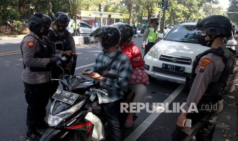 Petugas gabungan menghentikan dan memeriksa kendaraan berplat nomor luar Kota Solo yang melintas di Pos Simpang Faroka saat Razia Penyekatan di Solo, Jawa Tengah, Ahad (4/7/2021). Kegiatan tersebut merupakan penegakan aturan Pemberlakukan Pembatasan Kegiatan Masyarakat (PPKM) Darurat dari pemerintah guna memutus mata rantai penyebaran COVID-19. 