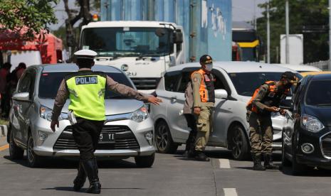 Petugas gabungan menghentikan kendaraan yang akan menuju Pulau Madura di akses masuk Jembatan Suramadu, Surabaya, Jawa Timur, Rabu (9/6/2021). Pihak kepolisian meminta pengendara untuk kembali dan tidak bepergian ke Pulau Madura jika tidak mempunyai keperluan yang penting menyusul meningkatnya jumlah kasus COVID-19 di Bangkalan, Madura.