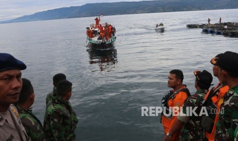 Petugas gabungan menunggu kapal SAR yang membawa kantong berisi jenazah korban KM Sinar Bangun yang tenggelam, bersandar di Pelabuhan Tigaras, Simalungun, Sumatera Utara, Rabu (20/6).