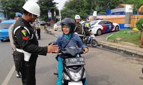 Petugas gabungan merazia kendaraan yang melintasi Jl Raya Purwakarta-Sadang, Kabupaten Purwakarta, Senin (5/11). Dalam razia ini, petugas masih menemukan stiker dari institusi TNI/Polri serta ormas yang dipasang di plat nomor kendaraan. 