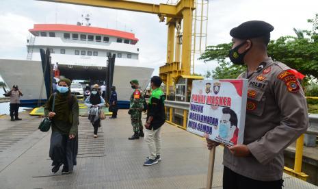 Petugas gabungan Polri,TNI dan Dinas Perhubungan mengimbau penumpang kapal mematuhi protokol kesehatan saat tiba di pelabuhan penyeberangan Ulee Lheue, Banda Aceh, Aceh, Sabtu (8/5/2021). Menjelang lebaran Idul Fitri, aktivitas penyeberangan Banda Aceh-Pulau Sabang tetap diperbolehkan beroperasi dengan pengetatan protokol kesehatan, tapi jumlah penumpang sejak tiga hari terakhir menurun rata-rata sehari hanya kisaran 70 penumpang yang diberangkatkan, baik dengan kapal cepat maupun kapal lambat. 