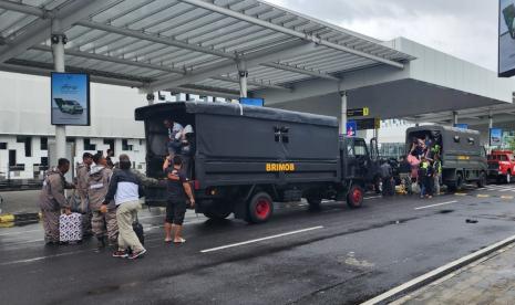 Petugas gabungan PT Angkasa Pura I, Lanumad Ahmad Yani Semarang dan Satuan Korps Brimob Polda Jawa Tengah menyediakan layanan penjemputan calon penumpang yang tertahan di luar bandara, akibat cuaca buruk di Kota semarang, Sabtu (31/12).