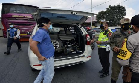 Petugas gabungan Satgas COVID-19 Kota Bandar Lampung memberhentikan dan memeriksa kendaraan asal luar Lampung yang melintas memasuki wilayah Kota Bandar Lampung, Lampung, Rabu (28/4/2021). Pemeriksaan dan penyekatan kendaraan yang dilakukan di lima titik pintu masuk Kota Bandar Lampung tersebut sebagai upaya meminimalisir penyebaran COVID-19 di Provinsi Lampung.