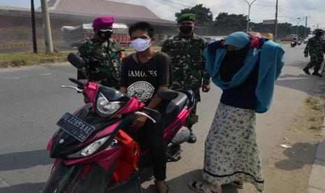 Petugas gabungan Satgas COVID-19 Kota Bandar Lampung memberhentikan pengendara motor yang tidak mengenakan masker saat berkendara di Kota Bandar Lampung, Lampung, Rabu (28/4/2021). Pemeriksaan dan penyekatan kendaraan yang dilakukan di lima titik pintu masuk Kota Bandar Lampung tersebut sebagai upaya meminimalisir penyebaran COVID-19 di Provinsi Lampung.