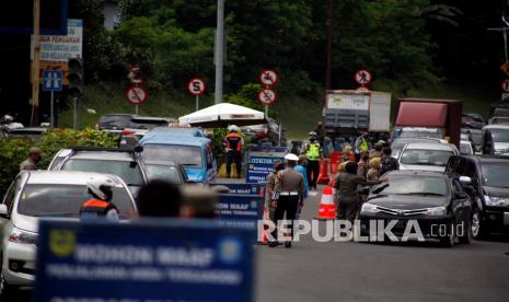 Petugas gabungan Satgas COVID-19 memeriksa kendaraan wisatawan di jalur wisata Puncak, Gadog, Kabupaten Bogor, Jawa Barat, Kamis (11/2). Polres Bogor, Polda Jawa Barat memberlakukan sistem satu arah secara situasional di jalur Puncak, Bogor. 