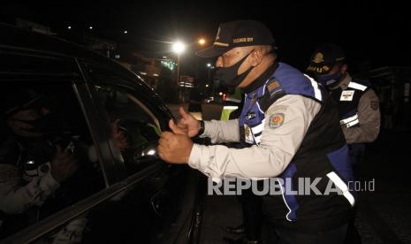 Petugas gabungan Satgas COVID-19 memeriksa kendaraan yang melintas di perbatasan wilayah Jawa Tengah dan Daerah Istimewa Yogyakarta di Prambanan, Sleman, DI Yogyakarta, Kamis (11/2/2021). Pemeriksaan dan penyekatan kendaraan dilakukan serentak di empat titik perbatasan wilayah DI Yogyakarta sebagai upaya meminimalisir penyebaran COVID-19 jelang libur Imlek. 